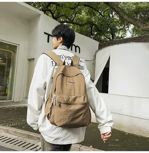 Outdoor back view of a khaki casual canvas backpack with large capacity and side pockets