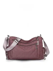 Front view of quilted nylon crossbody bag in dusty rose with multi-zipper pockets