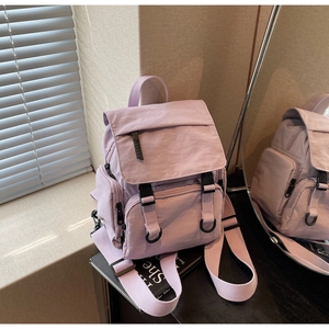 Macro detail of lavender nylon backpack with multi-pocket design and buckle closure