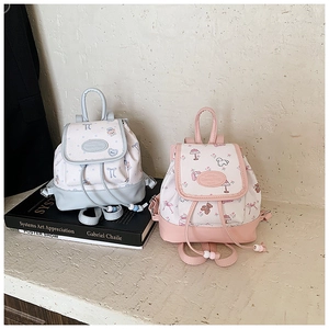 Detail of mini backpacks with cute cartoon prints in light blue and pink pastel colors