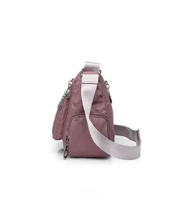 Side view of nylon crossbody bag with quilted pattern and adjustable grey shoulder strap