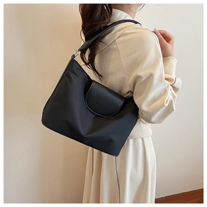 Close-up of matte leather flap with CLEAREK embossing on a black nylon tote bag