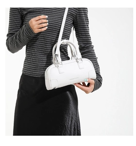 Détail d'un sac bowling blanc en cuir grainé avec l'inscription FASHION & BAGS imprimée