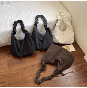 Detail of multi-color pleated fabric hobo bags showing textured material and ruched handles