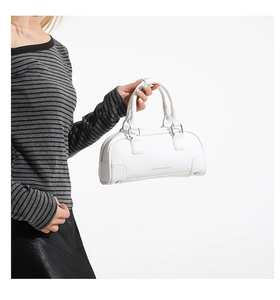 Détail d'un sac bowling blanc en cuir grainé avec anneaux argentés et logo embossé