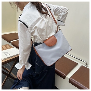 Detailed shot of large color-block tote bag with leather flap and brand embossing