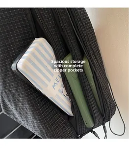 Close-up of black grid patterned crossbody bag with phone and power bank in zipper pockets