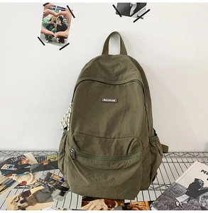 Close-up of army green canvas backpack featuring large main compartment and brand label