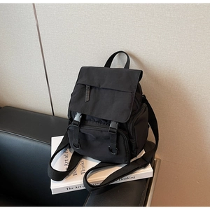 Detail view of black nylon multi-pocket backpack with adjustable buckle and zipper closure