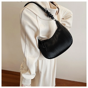 Detail shot of the black pleated texture and knotted strap on this hobo underarm bag