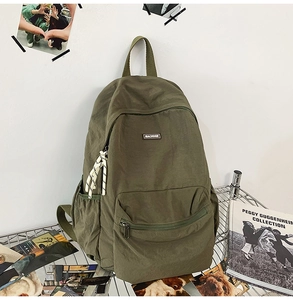 Detail view of military green canvas backpack showing Machado logo and durable water-resistant fabric