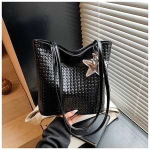 Detail of black woven texture on a large bucket bag with a silver star pendant