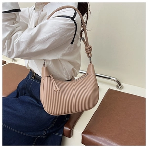 Detailed view of beige pleated bucket bag with handcrafted knot on the shoulder strap