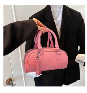 Gros plan détaillé du sac bowling rose en cuir grainé avec finitions argentées