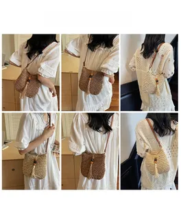 Modella che mostra la borsa a secchiello intrecciata boho con nappe e perline in interni