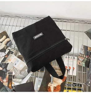 Close-up of black canvas storage bag with MACHUGE logo patch and metal zipper