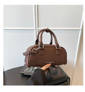 Détail du sac bowling en cuir marron foncé avec motif lychee et imprimé blanc