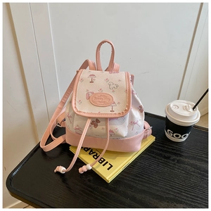 Detail of mini floral backpack with pink trim, drawstring closure, and cartoon print