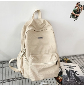 Detailed shot of beige nylon backpack with large main compartment and front zipper pocket