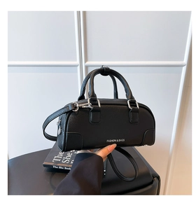 Détail du sac bowling en cuir grainé noir avec finitions argentées et texte fashion