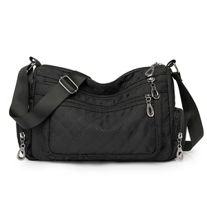 Detail of black nylon crossbody bag featuring quilted lattice pattern and multi-pocket design