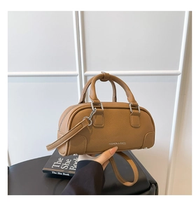 Détail du sac bowling en cuir marron à texture lychee avec ferrures argentées et anses