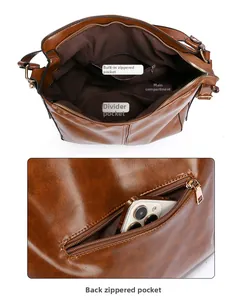 Vista interna della borsa a secchiello in pelle marrone con scomparti e tasche con zip