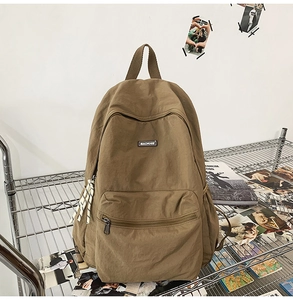 Close-up of brown nylon backpack with MACHUGE label and checkered zipper puller