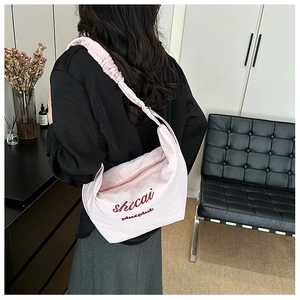 Detail of light pink pleated hobo bag with shoulder strap ruching and brand embroidery