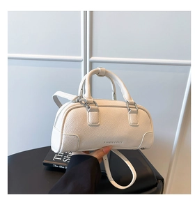 Détail du cuir grainé blanc et de l'inscription argentée FASHION & BAGS sur le sac à main