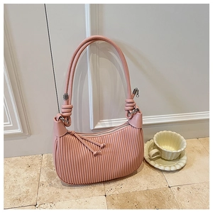 Detailed close-up of pink pleated dumpling bag with elegant knotted straps and metal hardware