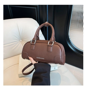 Détail du sac à main marron avec motif litchi, boucles argentées et texte tendance