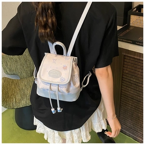 Rear view of a stylish mini backpack with cartoon prints and drawstring top on model