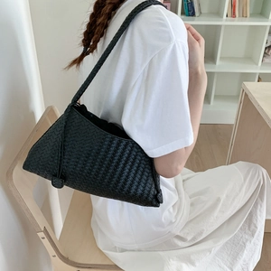 Detail einer schwarzen geflochtenen Leder-Schultertasche mit eleganter Textur am Modell