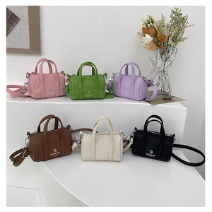 Close-up of mini cylindrical pillow bags in various colors with star print and straps