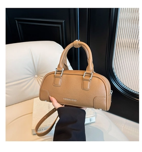 Détail d'un sac à main marron en cuir grainé avec finitions argentées et logo chic