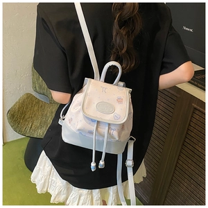 Detail view of mini backpack featuring cartoon bear patterns and drawstring closure