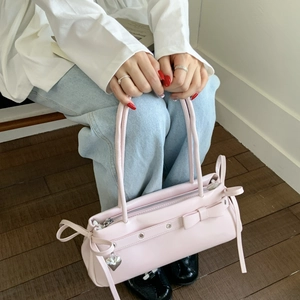 Detailed view of baby pink Y2K shoulder bag with bow ribbon and heart charm