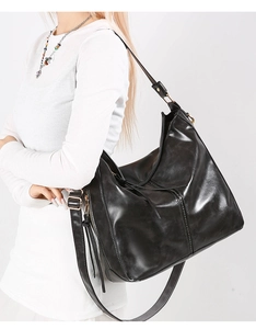 Dettaglio borsa hobo in pelle nera lucida con cerniera a nappe e ampio interno