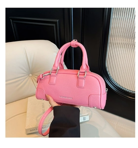 Détail du sac à main rose en cuir grainé avec bandoulière réglable et texte logo argenté