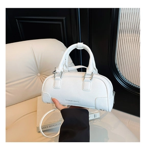 Gros plan du sac Boston en cuir grainé blanc avec fermetures éclair et boucles en argent
