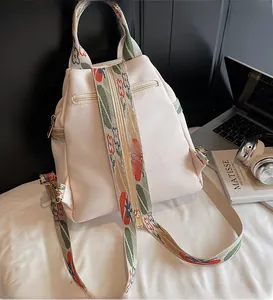 Détail du sac à dos en nylon beige avec sangles ethniques et poches zippées fluides