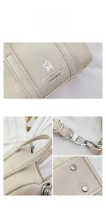 Detail of off-white lychee leather texture with silver hardware and logo on mini pillow bag