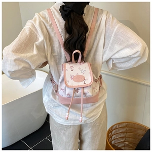 Detail of a mini pink and white floral backpack with drawstring closure and cute prints