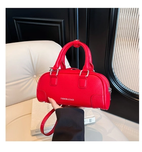 Vue détaillée du sac bowling en cuir rouge texturé avec fermeture éclair en métal argenté