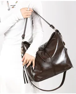 Dettaglio della borsa a secchiello vintage marrone scuro con elegante nappa e tracolla