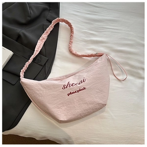 Detail of pink crescent bag showing shirred shoulder strap and pleated fabric texture
