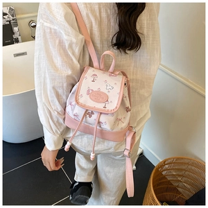 Detail of pink and white canvas backpack with cute puppy illustrations and drawstring