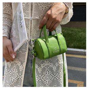 Detailed macro view of the lime green litchi texture on this mini barrel crossbody bag