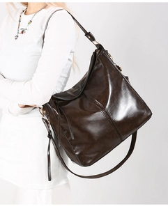 Dettaglio borsa a secchiello in pelle lucida marrone scuro con cuciture verticali